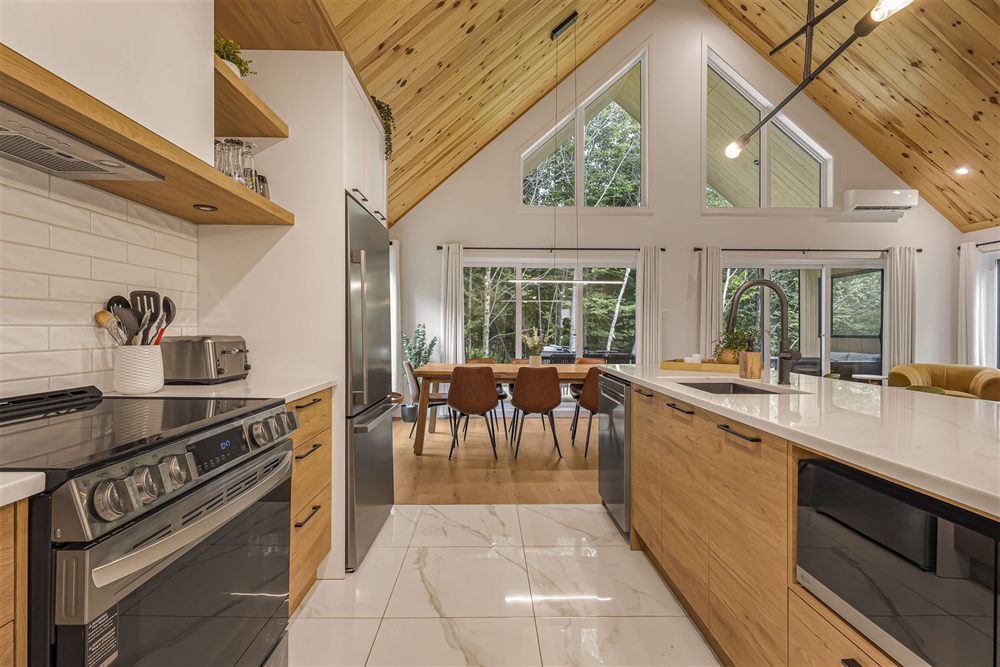 Cuisine ouverte sur salle à manger, plafond cathédrale en bois